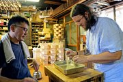 伝統工芸士の西田恵一さん（左）から曲げ物の技術指導を受けるブレンダン・ガフニーさん＝高山市内
