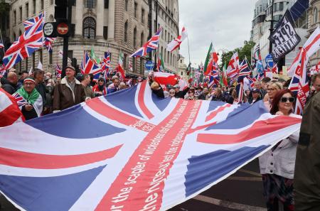 　１６日、ロンドンで極右活動家が主催したデモに参加し、英国旗を広げる人たち（共同）