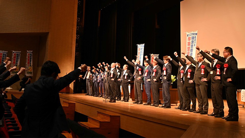 早期整備を要望する総会決議を採択し、ガンバロー三唱で結束を固める出席者＝瑞浪市土岐町、市総合文化センター