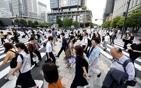 　東京・丸の内のオフィス街を行き交う人たち＝７月