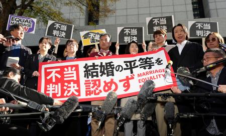 　同性カップルら８人が国に損害賠償を求めた東京第２次訴訟の控訴審判決を受け「不当判決」などと書かれた紙を掲げる原告ら＝２８日午前、東京高裁