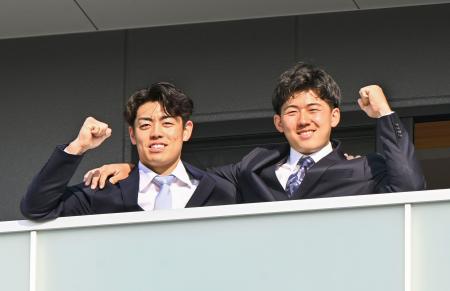 　入寮し、ガッツポーズする阪神ドラフト１位の立石（右）と２位の谷端＝５日、兵庫県尼崎市