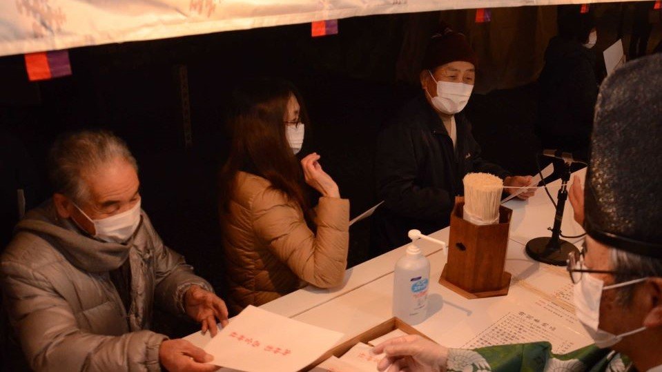 お札を受け取り、福引をする参拝客＝中津川市えびす町、西宮神社