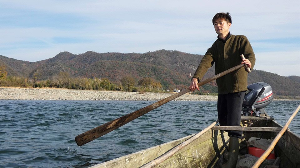 今も木造船で漁を行い、川を伝って板場に川魚を運ぶ平工顕太郎さん。川は昔の物流ルートだった＝岐阜市、長良川