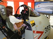 Ｆ４戦闘機の模擬コックピットに乗って操縦を体験する女性＝岐阜市神田町、自衛館