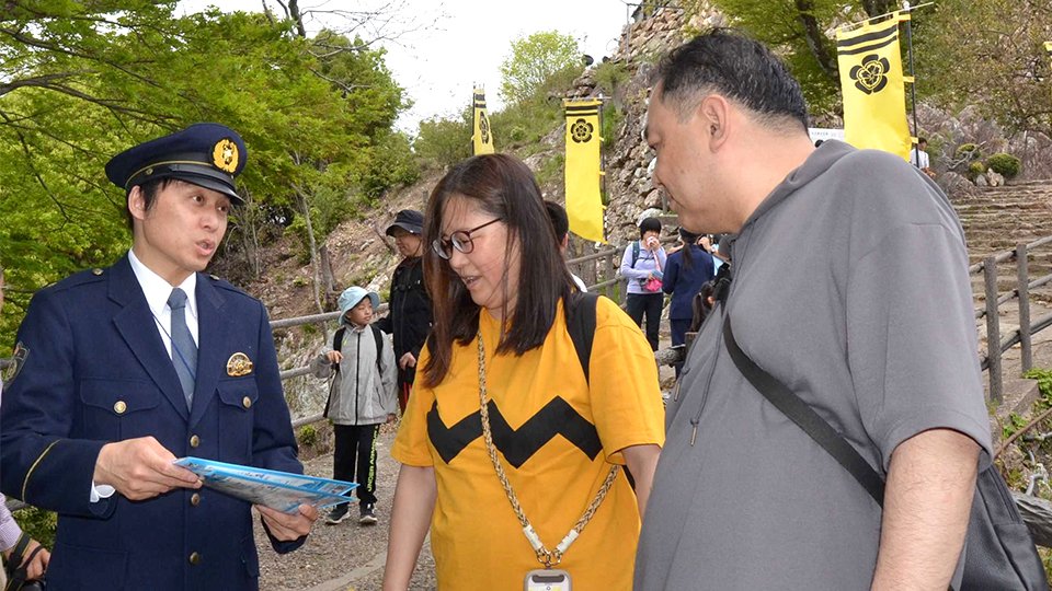 注意して下山するよう行楽客に呼びかける署員＝岐阜市、金華山