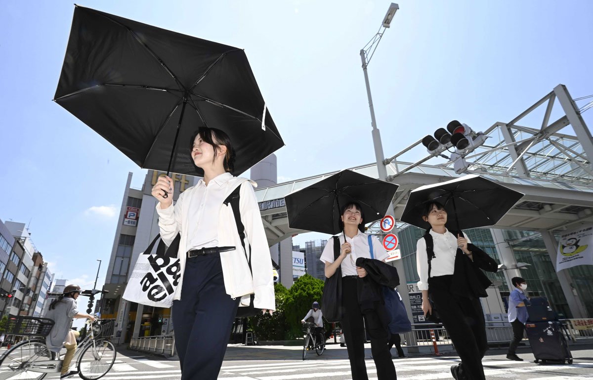 梅雨明けの晴天の下、日傘を差して歩く人たち＝２０日午前１１時６分、岐阜市神田町（撮影・堀尚人）