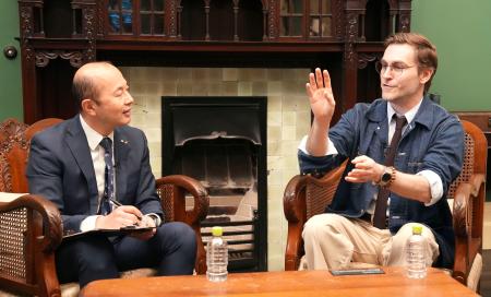 　長崎市の鈴木史朗市長（左）と対談するクレイグ・モドさん＝１９日午後、長崎市