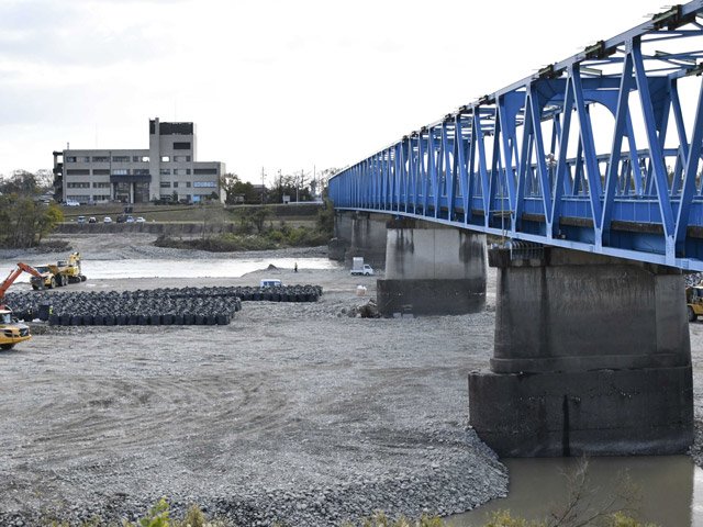 川島大橋付近で増水時に工事現場を守るための土のうを設置する重機＝各務原市川島笠田町