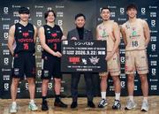 　バスケットボール「Ｂリーグ・プレミア」などの日程が決まり、写真に納まるＡ東京（左）と琉球の選手ら。中央は島田慎二チェアマン＝１７日、東京都内