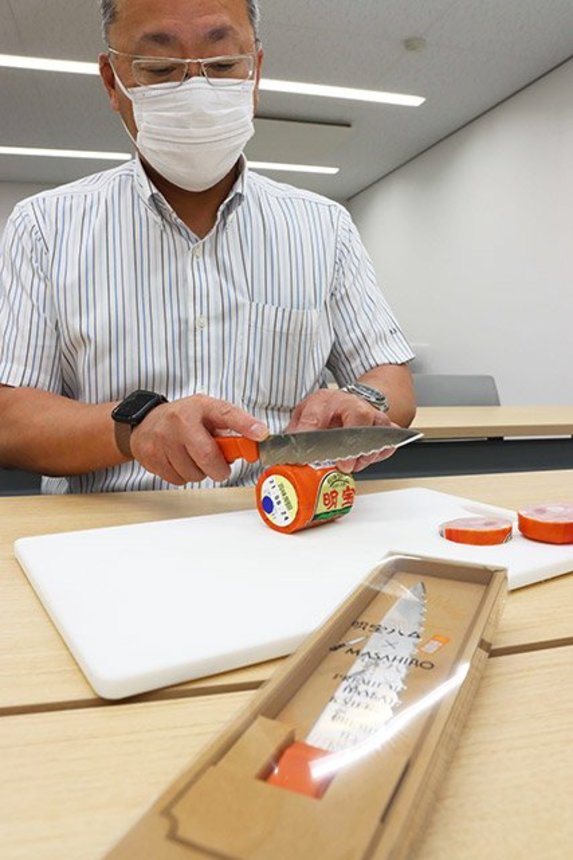 プレミアムハムナイフの切れ味を実演する名畑和永専務＝郡上市明宝気良、明宝特産物加工