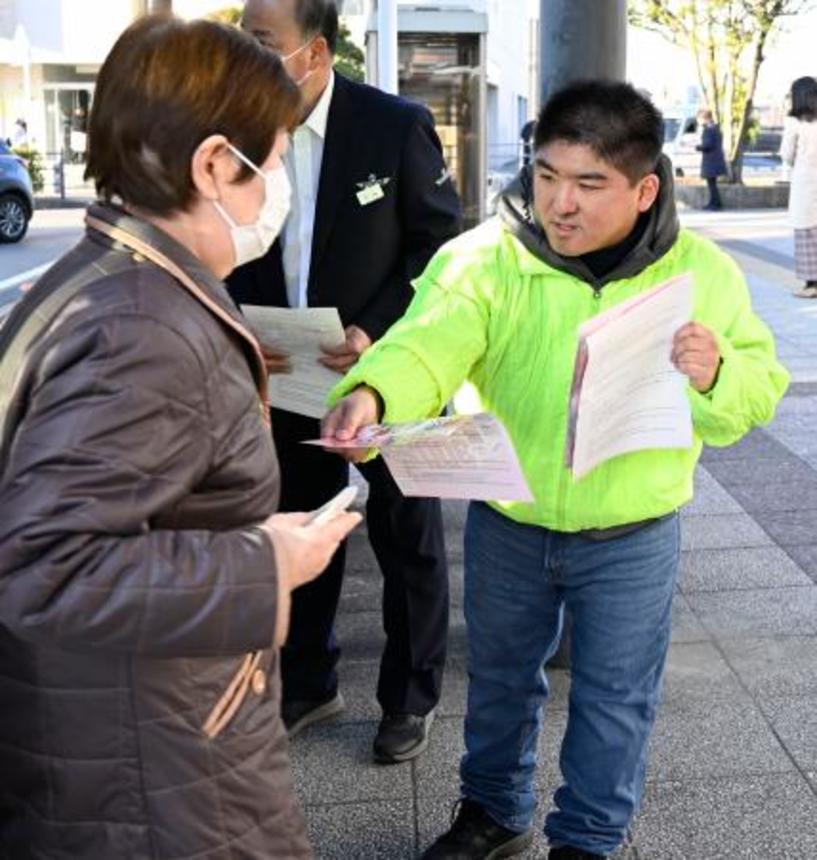 　ＪＲ姉ケ崎駅で情報提供を求めるチラシを配る曽根貴佑さん（右）＝５日午前、千葉県市原市