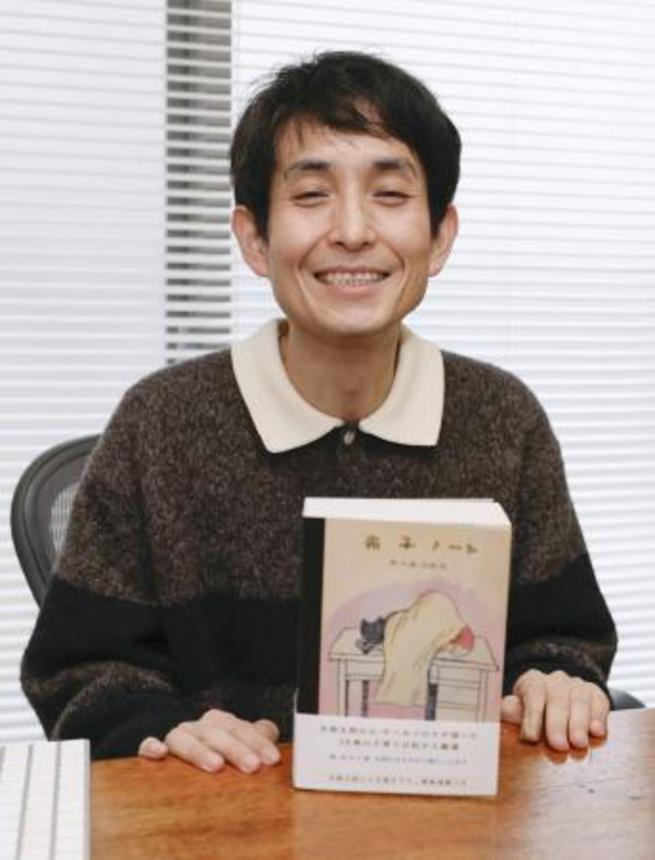 　出版した書籍と記念撮影する矢部太郎さん＝東京都内