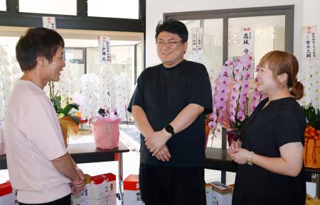 　旅館「はまづる」の営業再開セレモニーを終え、和倉温泉の関係者と談笑する高城一博さん（中央）＝２日午後、石川県七尾市