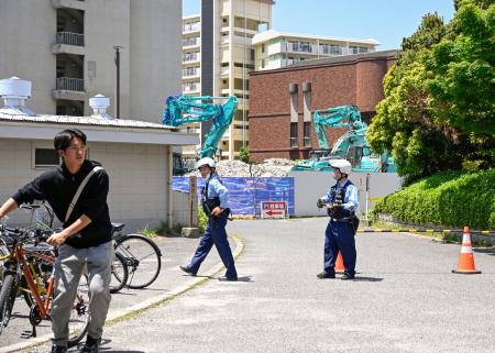 　不発弾らしき物が見つかった広島大霞キャンパス内の工事現場付近で、警戒する警察官＝１３日午後０時２５分、広島市南区