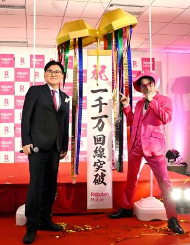 　携帯電話の契約が１千万回線を突破し、写真に納まる楽天モバイルの三木谷浩史会長（左）ら＝２５日午後、東京都新宿区