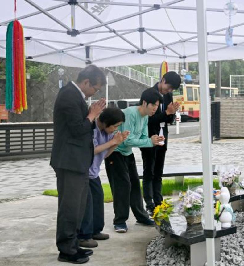 　津久井やまゆり園の献花式で、花を手向け手を合わせる入所者と職員＝１１日午前、相模原市
