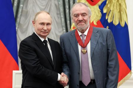 　モスクワのクレムリンで、指揮者のゲルギエフ氏（右）に勲章を授与して握手するロシアのプーチン大統領＝２０２４年５月（タス＝共同）
