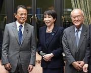 　　２０２６年度予算案が衆院を通過後、自民党の麻生副総裁（左）と笑顔で言葉を交わす高市首相。右は鈴木幹事長＝３月１３日、国会