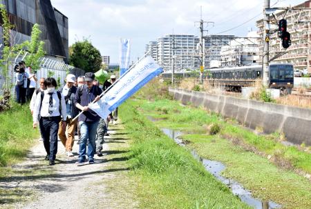 　ＪＲ脱線事故の負傷者らでつくる「空色の会」が開催した「メモリアルウオーク」。右はＪＲ福知山線＝１８日午後、兵庫県尼崎市