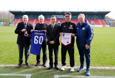 　スコットランドのスターリングの本拠地を訪問し、関係者と写真に納まる日本サッカー協会の山本ナショナルチームダイレクター（右から２人目）。左端はジョン・オールさん＝２４日、スターリング（共同）