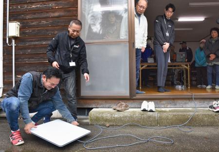 　衛星インターネットサービス「スターリンク」を設置する住民ら＝２日午前、石川県かほく市