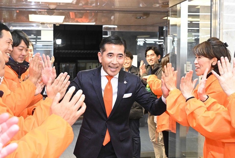 中津川市長選で初当選を果たし、支持者に迎えられる小栗仁志氏＝１４日午後１０時４６分、中津川市太田町