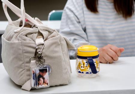　取材に応じる塚越寛人さんの妻。バッグには亡くなった寛人さんと湊斗ちゃんの写真が入ったキーホルダーが付けられていた＝４月、前橋市