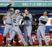 　９回、決勝本塁打を放った坂本（手前）を迎える阪神ナイン＝神宮