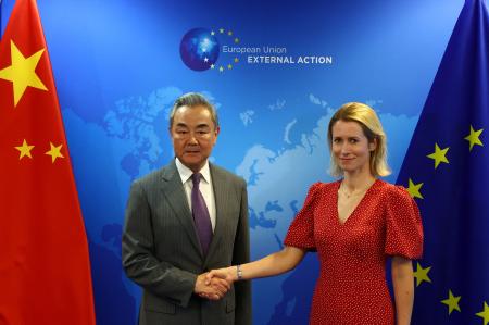 　２日、中国の王毅外相（左）と握手する欧州連合（ＥＵ）のカラス外交安全保障上級代表＝ブリュッセル（ロイター＝共同）