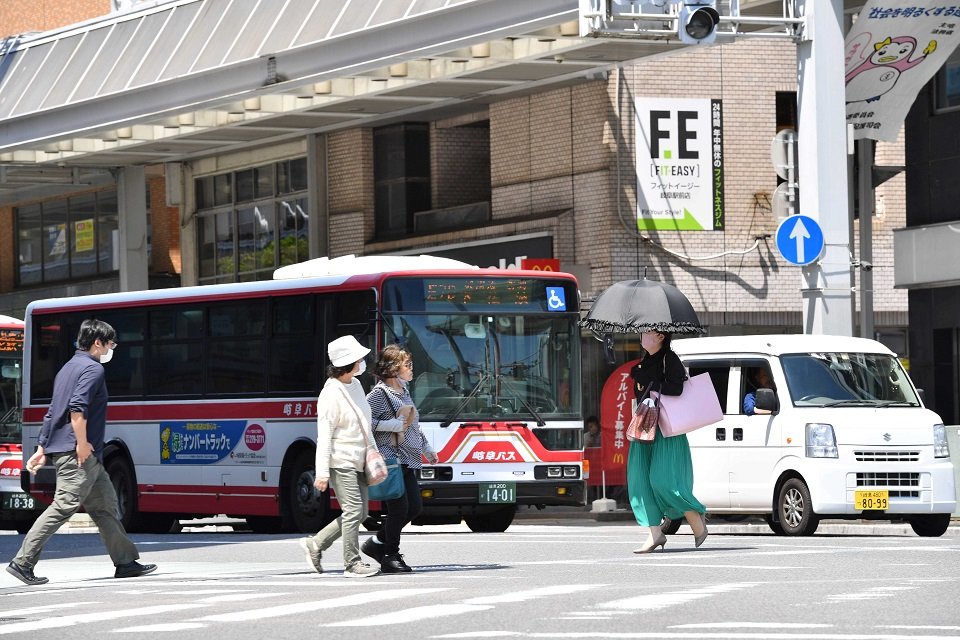 今年初の猛暑日となり、日傘を差して歩く女性ら＝４日午後１時２９分、岐阜市神田町