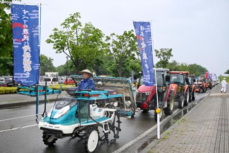 　デモ行進する田植え機やトラクター＝１４日午後、新潟県長岡市
