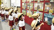 作中に出てくる駄菓子の立体造形などを興味深そうに見学する園児＝岐阜市正木中、マーサ２１