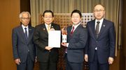 岐阜県初となるウイスキー専門蒸留所の開設計画を報告した舩坂酒造店の有巣弘城社長（右から２人目）＝高山市役所