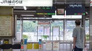 台風１４号の影響で、中央線が始発から運転見合わせとなり、電光掲示板を見つめる利用客＝２０日午前８時１３分、中津川市太田町、ＪＲ中津川駅