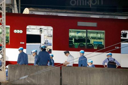 　脱線した近鉄京都線の車両付近で作業する人たち＝３０日午前０時４６分、京都市
