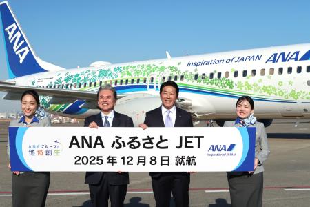 　羽田―鳥取間で就航した特別デザイン機「ＡＮＡふるさとＪＥＴ」の前で撮影に応じる関係者ら＝８日午後、羽田空港
