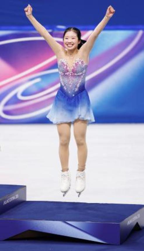 　表彰台に跳び乗る中井亜美。銅メダルを獲得した＝ミラノ（共同）