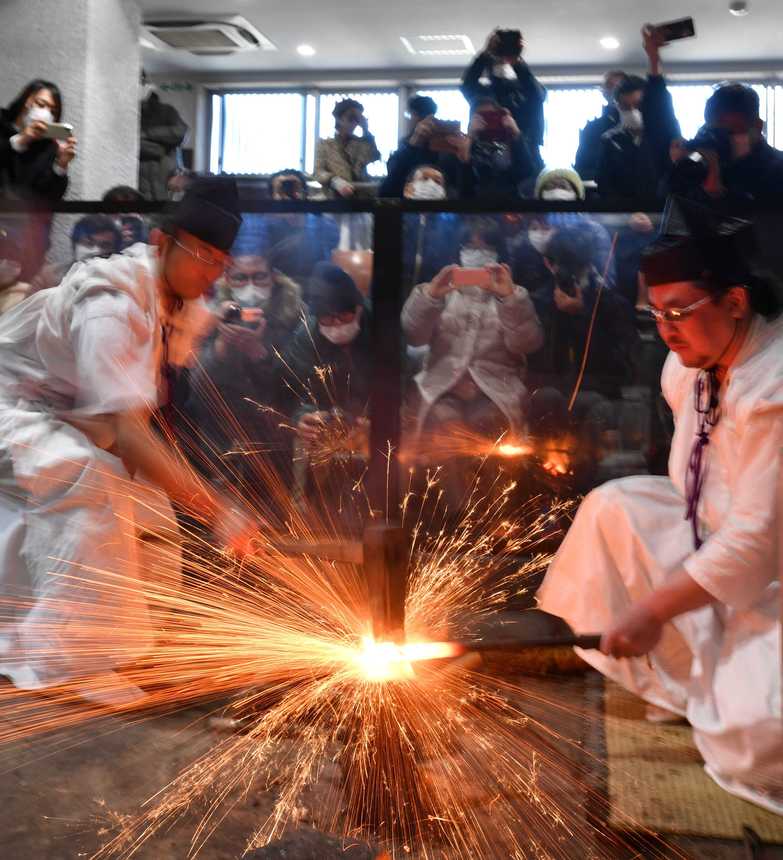 打ち初め式で火花を散らして日本刀の鍛錬を披露する刀匠＝２日午前１０時５０分、関市南春日町、関鍛冶伝承館