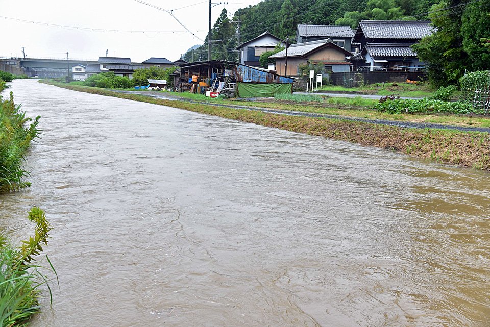 岐阜ファミリーパーク付近の石田川。道の高さまで増水した＝１６日、午後４時５１分、岐阜県岐阜市北野北