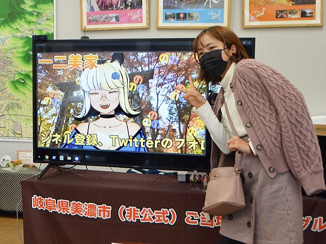 一二美家のキャラクターと一緒に写真に収まる来場者＝美濃市加治屋町、観光案内所番屋