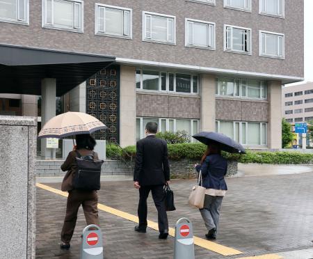　解雇無効の仮処分申し立てのため、札幌地裁に入る専門学校に勤めていた男性教員（中央）ら＝３０日午前