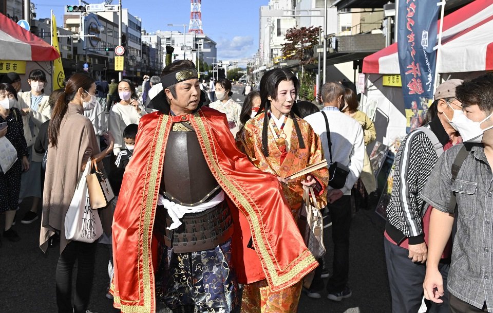 ぎふ信長まつり初日、タイムスリップ企画で街歩きを楽しむ公募の織田信長と濃姫＝５日午後、岐阜市金町、金華橋通り