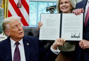 　ホワイトハウスで署名した覚書を誇示するトランプ米大統領＝１５日、ワシントン（ロイター＝共同）