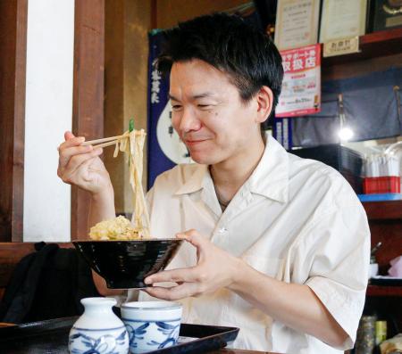 　うどんを食べるユーチューバーの武正倫さん＝７月、埼玉県内