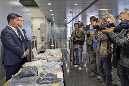 　香港で現金約１０億円が強奪された事件で、押収した服などを撮影する報道陣＝２２日（共同）