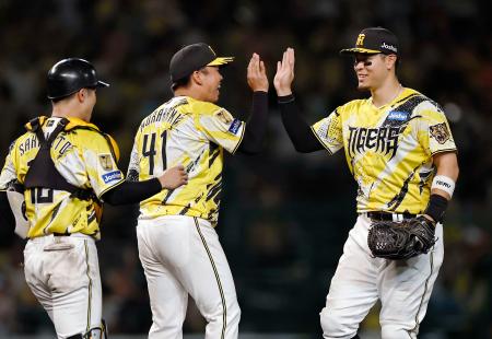 　巨人に勝利し、タッチを交わす阪神・村上（中央）と佐藤＝甲子園