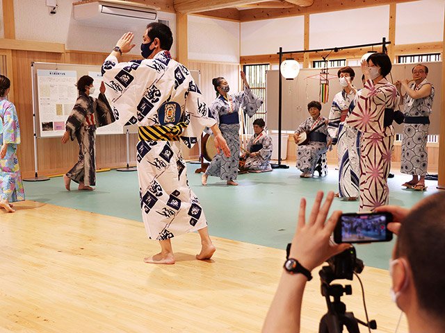 撮影で踊りの輪をつくる八幡おはやしクラブの会員ら＝郡上市八幡町殿町、郡上八幡まちなみ交流館