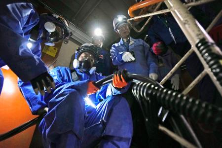 　新潟県の柏崎刈羽原発６号機原子炉建屋内で行われた、外部電源を確保する訓練を視察する花角英世知事（右）＝１４日午前