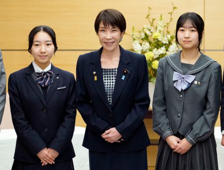 　北方領土に関する高校生の弁論大会で受賞した河森絢音さん（右）、三浦かんなさん（左）と写真に納まる高市首相＝１０日午前、首相官邸